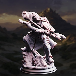 May include: A detailed figurine of a warrior in a dynamic pose, holding a spear and shield. The figure is clad in armor and stands atop a textured base. The background features a blurred landscape with a mountain range, creating a fantasy theme.