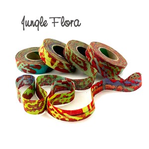 May include: Four spools of colorful fabric ribbon with a jungle flora print. The ribbon is red, green, yellow, and blue.