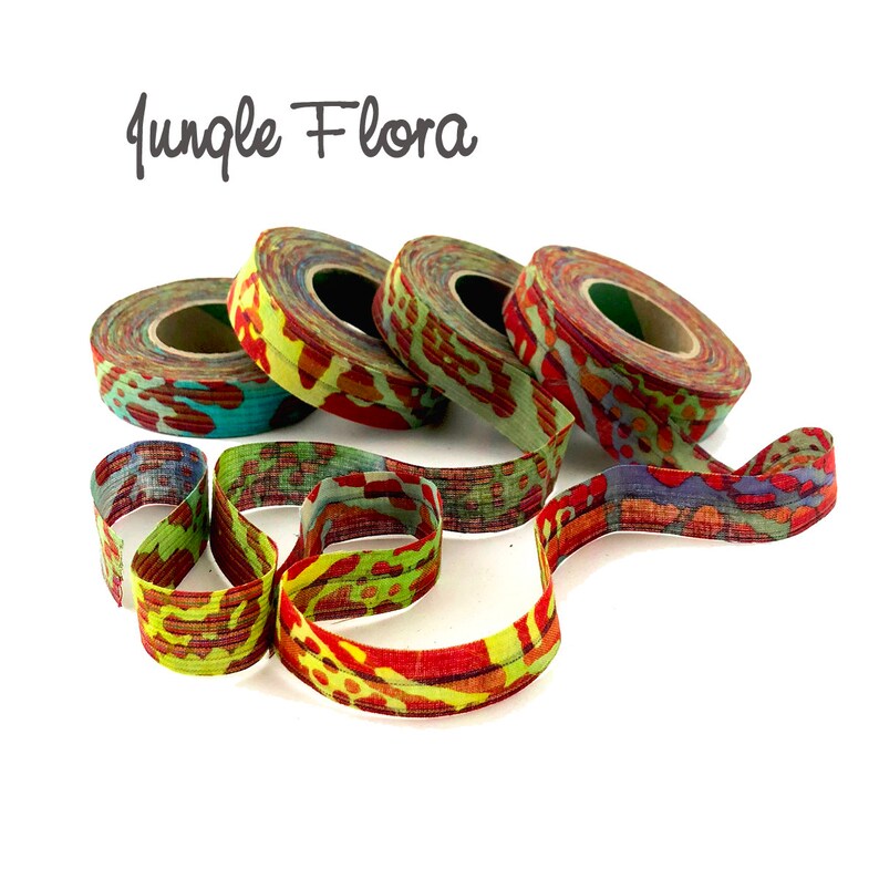 May include: Four spools of colorful fabric ribbon with a jungle flora print. The ribbon is red, green, yellow, and blue.