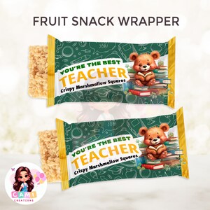 Puede incluir: Envoltorio de aperitivo verde y amarillo con un oso de dibujos animados sosteniendo un libro. El envoltorio dice "You're the best teacher" y "Crispy Marshmallow Squares".