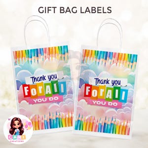 Puede incluir: Dos bolsas de regalo blancas con asas, con un dise&ntilde;o colorido de l&aacute;pices y nubes. Las bolsas tienen un mensaje de agradecimiento que dice "Gracias por todo lo que haces".