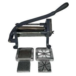 May include: A dark grey manual vegetable cutter with a long lever handle and a metal frame. The device includes two interchangeable square cutting blades and two corresponding metal push blocks for dicing and wedging vegetables into various shapes.