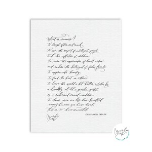 May include: A white print with elegant calligraphy. The text reads "What is success?" followed by a quote by Ralph Waldo Emerson. The print features a signature and a small logo in the bottom right corner.