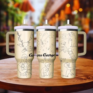 May include: Three stainless steel travel mugs with a cream coloured background and black line drawings of Curious George. The mugs have a handle and a lid with a straw.