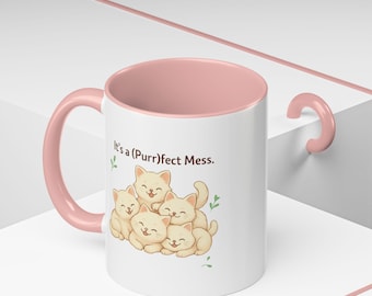 Può includere: Tazza in ceramica bianca con interno e manico rosa. La tazza presenta un'illustrazione a cartoni animati di cinque gattini sorridenti e il testo "It's a (Purr)fect Mess."