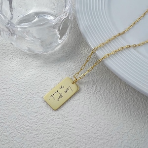 Joyería con escritura grabada: texto manuscrito personalizado en etiqueta rectangular, collar de recuerdo.