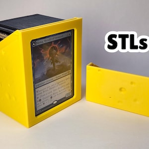 May include: A bright yellow card holder with a card inside, and a separate matching piece. The card holder is designed to hold a deck of cards. The text "STLs" is visible in the image.