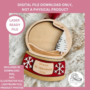 May include: A laser-cut wooden snow globe ornament with a red and gold base. The snow globe has a cutout for a photo and the text "Chloe's 1st Christmas 2024".