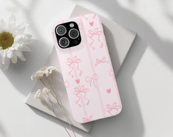 May include: A pink phone case with a pattern of pink bows and hearts. The case is designed for an iPhone with a camera bump.