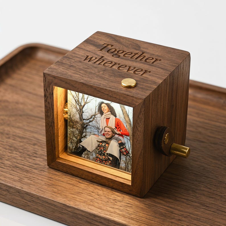 May include: A wooden music box with a photo display. The box is engraved with the words "Together wherever". The photo shows two people. The box has a gold-coloured knob and button.