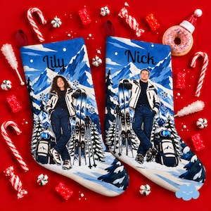 Könnte beinhalten: Zwei blaue Weihnachtsstrümpfe mit einer verschneiten Berglandschaft und Tannenbäumen. Ein Strumpf zeigt eine Person namens Lily, der andere eine Person namens Nick. Beide tragen Skiausrüstung mit Skiern und Rucksäcken.