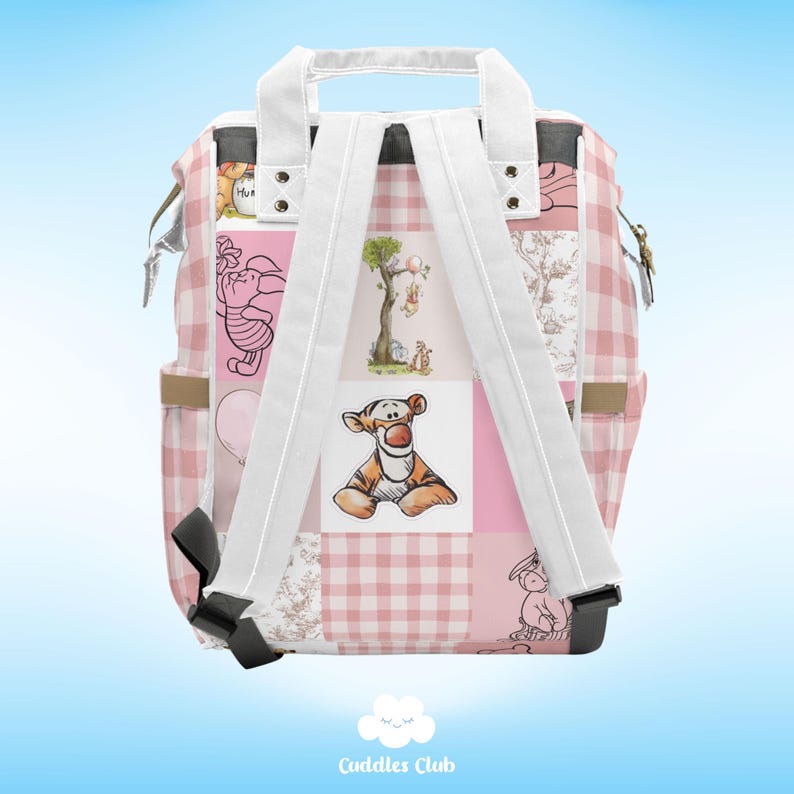 May include: Pink and white checkered backpack with a patchwork design featuring Winnie the Pooh and Tigger characters. The backpack has adjustable straps and a top handle.