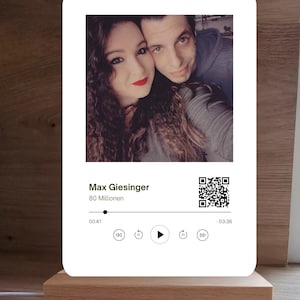 Könnte beinhalten: Ein weißer digitaler Bilderrahmen mit einem Bild eines Paares. Der Rahmen verfügt über eine Musikplayer-Oberfläche mit Steuerelementen zum Abspielen, Pausieren, Zurückspulen und Vorspulen. Der Text "Max Giesinger 80 Millionen" wird auf dem Rahmen angezeigt.