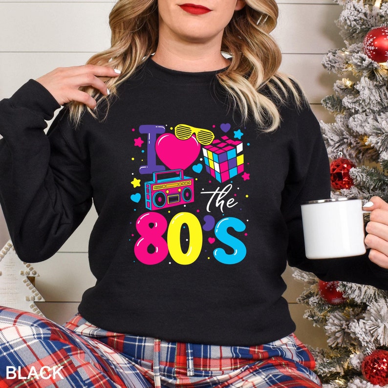 a woman wearing a black sweatshirt with the words i love the 80's on