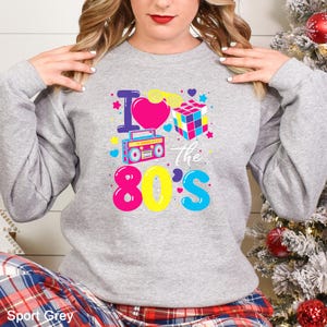 a woman wearing a sweatshirt that says i love the 80's