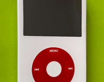 以下が含まれることがあります： 「MENU」と書いてある赤い丸いボタンが付いた白いiPod。ボタンの中央には白い円があり、円の両側には白いボタンがあります。iPodは黒い画面です。