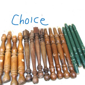 May include: A collection of 15 wooden chair legs, some with a turned design, and 4 green painted legs. The legs are all different lengths and styles.  The word "Choice" is written in blue on a white background.