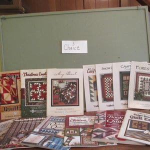 May include: A collection of 13 quilting patterns featuring various designs, including "Christmas Countdown", "My Best", "Lazy Days", "Snow Flakes", "Campfire Flames", "Forest View", "Scraps", "The Book of Quilts", "Paint Box Quilt Express", "Christmas Street", "Autumn Quilt", and "Quilts".