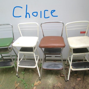 May include: Four vintage step stools with metal frames and various seat colors: green, white, brown, and off-white. Each stool has a step and a backrest. The word "Choice" is written in blue on the wall behind the stools.