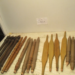 May include: A collection of wooden chair legs in various styles and finishes. Some legs are plain, while others have decorative carvings. The legs are arranged on a white surface. The word "Choice" is written on a piece of paper in the background.