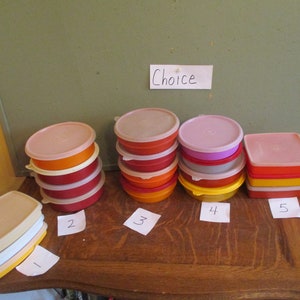 May include: A collection of colorful plastic food storage containers with lids. The containers are in various shapes, including round and rectangular, and come in shades of pink, orange, red, yellow, and white. The word "Choice" is written on a piece of paper.