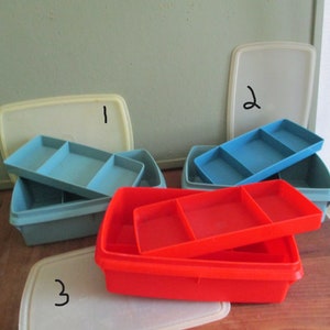 May include: Three plastic storage containers with lids. The containers are blue, red, and white. The lids are labeled with the numbers 1, 2, and 3.