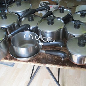 May include: A set of stainless steel cookware with black handles. The cookware includes pots and pans of various sizes.