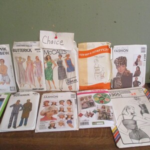 May include: A collection of vintage sewing patterns for various clothing items, including dresses, tops, pants, and underwear. The patterns are from different brands, including Kwik Sew, Butterick, McCall's, and Simplicity. The patterns are in various colors, including pink, blue, green, and yellow.