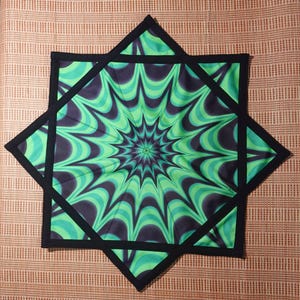 May include: A green and black star-shaped fabric coaster with a swirling pattern. The coaster has a black border.