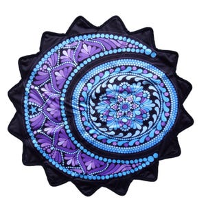 Può includere: Un tappetino circolare con bordo smerlato, sfondo nero e un vivace motivo mandala nelle tonalità del viola, lavanda e blu brillante. Il design è composto da cerchi concentrici, forme a petalo e piccoli punti.