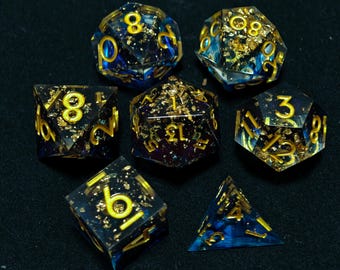 Peut inclure: Ensemble de sept dés polyédriques avec des paillettes dorées et des tourbillons bleus et violets. Les dés sont en résine transparente et portent des chiffres dorés.