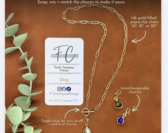 May include: A 14k gold-filled paperclip chain necklace with a toggle clasp and three interchangeable charms. The text reads: The Everyday Link Necklace, Swap, mix + match the charms to make it yours, 14k gold-filled paperclip chain 16", 18", or 20", Toggle clasp for easy on-off + switch of charms, Interchangeable charms, Each necklace comes with 3 interchangeable charms, with the option to add on more.