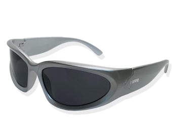 May include: Silver-colored sunglasses with a wraparound design and dark gray lenses. The sunglasses have a subtle curve to the frame and the brand name "LUDIW" is printed on the right temple.