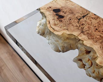 May include: A rectangular console table featuring a polished, reflective mirrored surface on one side and a natural, raw-edged light brown wood burl slab on the other, showcasing intricate grain patterns, dark knots, and a textured, organic edge.