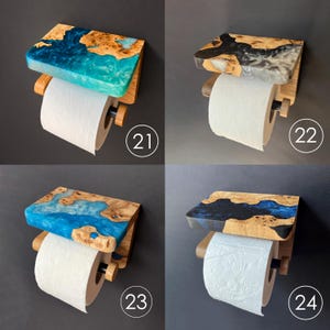 May include: Four wall-mounted toilet paper holders featuring a wooden shelf with embedded colored resin. Each unit includes a horizontal rod for a roll of toilet paper. The resin colors include bright blue, grey, light blue, and dark blue.