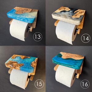 May include: Four wall-mounted toilet paper holders featuring a wooden shelf with embedded resin in shades of blue, grey, and teal. Each unit includes a wooden dowel arm and a cylindrical end cap to secure a roll of white toilet paper.