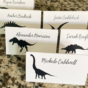 Dinosaur Place Card, bedrukt met de naam en tafel van uw gast, kies kleuren, lettertype, dinosaurussen, arriveer gevouwen en klaar voor gebruik
