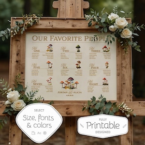 May include: A wooden easel holding a wedding seating chart titled Our Favorite People, featuring mushroom illustrations, table numbers, guest names, and the text Jordan and Alicia 4.18.2025, decorated with white roses and green eucalyptus foliage.