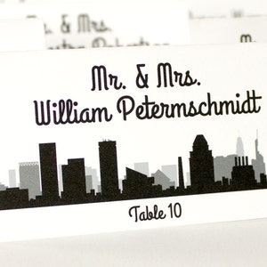 Baltimore Skyline bedrukte en gevouwen plaatskaart met gastnaam en tafel voor bruiloften of feesten, kies lettertype en kleur