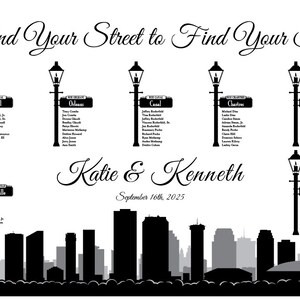 May include: Black and white wedding seating chart with a New Orleans skyline backdrop. The chart features street names like Royal, Orleans, Canal, Chartres, Dauphine, and Bourbon. Each street name has a list of guest names underneath.