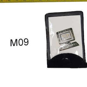 May include: A pin featuring a computer design with the text "ELECTRONIC DATA PROCESSING" and "LOCAL 2627". The pin is in a black case with the text "NEW YORK CITY" and "DC 37, AFSCME".