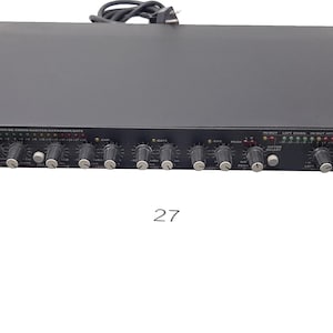 Puede incluir: Un mezclador de audio negro con una placa frontal plateada y un logotipo rojo y blanco que dice "ART Audio." El mezclador tiene múltiples perillas y deslizadores, y una pantalla digital.