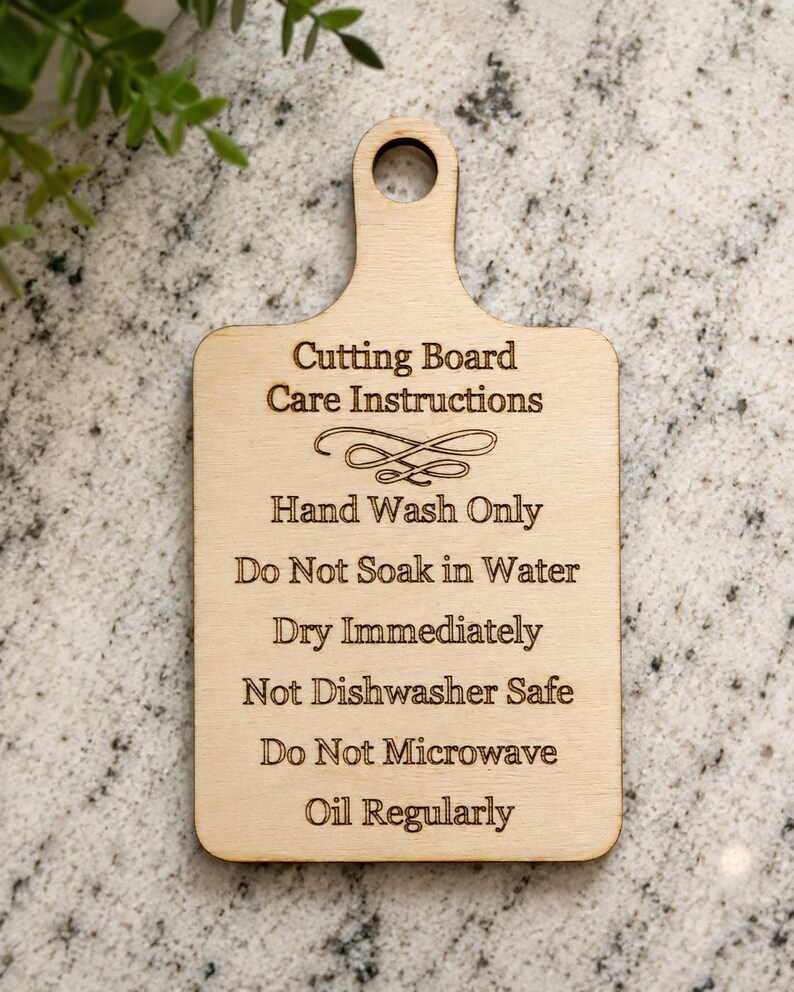 K&ouml;nnte beinhalten: Ein helles Holzschneidebrett mit einem Griffloch, das den lasergravierten Text tr&auml;gt: Cutting Board Care Instructions, Hand Wash Only, Do Not Soak in Water, Dry Immediately, Not Dishwasher Safe, Do Not Microwave und Oil Regularly.