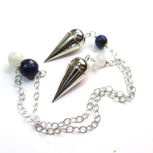 May include: Two silver-toned metal conical pendulums attached to silver-colored chains. Each chain features a dark blue spherical bead and a smaller white spherical bead. The pendulums have a smooth, reflective surface and a pointed tip design.