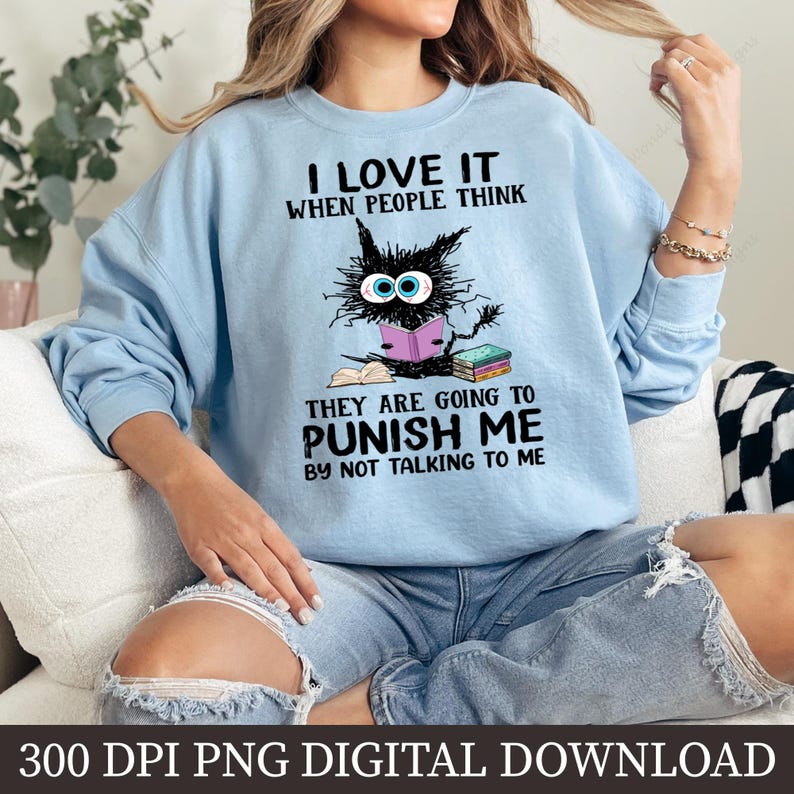 May include: A light blue sweatshirt with a black cat reading a book. The text on the sweatshirt says "I love it when people think they are going to punish me by not talking to me".