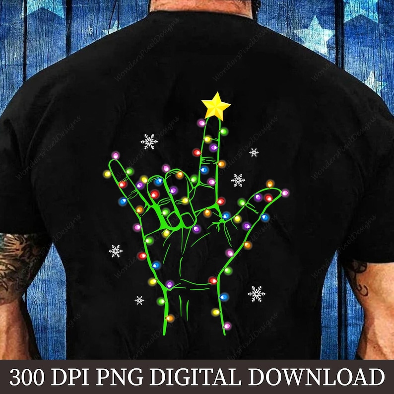 May include: Black t-shirt featuring a green hand in the shape of the "I love you" sign, decorated with colorful Christmas lights and a yellow star. White snowflakes are scattered around the hand. The text "300 DPI PNG DIGITAL DOWNLOAD" is at the bottom.