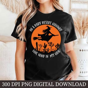 Puede incluir: Camiseta negra con un diseño gráfico circular naranja que representa una bruja en una escoba, cactus y el texto "ON A DARK DESERT HIGHWAY COOL WIND IN MY HAIR". Descarga digital.