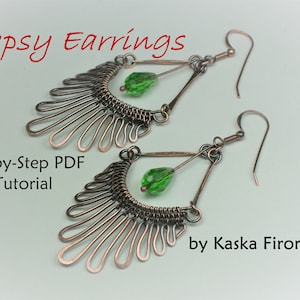 May include: A pair of copper wire earrings with green glass beads hanging from them. The earrings are in the shape of a fan with a triangle at the top. The earrings are handmade and come with a step-by-step PDF tutorial. "Gypsy Earrings by Kaska Firor"