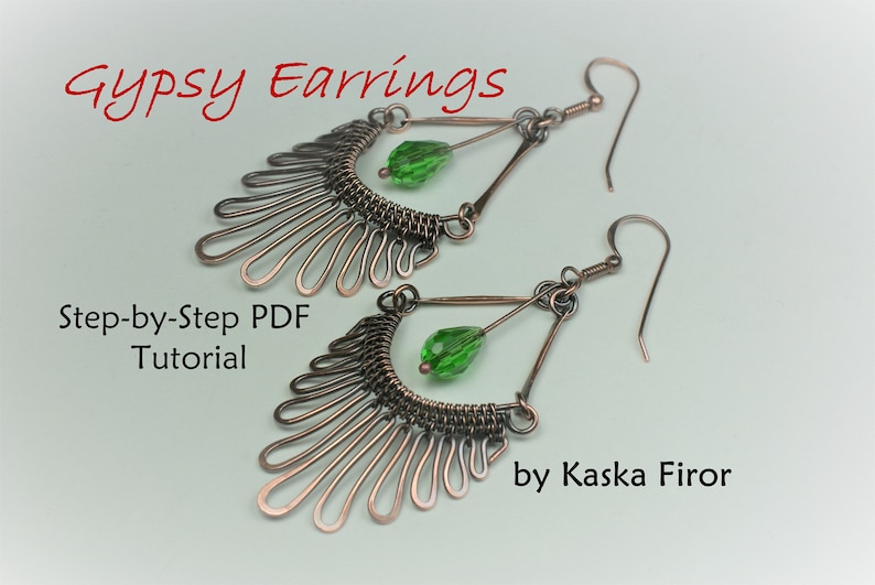 May include: A pair of copper wire earrings with green glass beads hanging from them. The earrings are in the shape of a fan with a triangle at the top. The earrings are handmade and come with a step-by-step PDF tutorial. "Gypsy Earrings by Kaska Firor"
