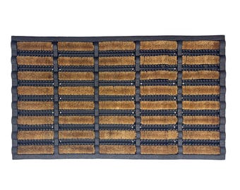 May include: Rectangular doormat with a dark grey border and a pattern of alternating brown and dark grey rectangular sections. The brown sections appear to be made of a natural fibre material, while the dark grey sections have a ribbed texture.